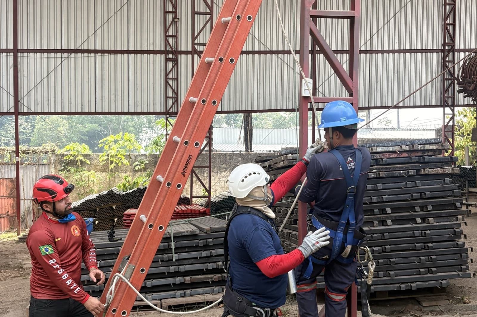 Instrutor confere o cinto de segurança de um participante antes da subida na escada