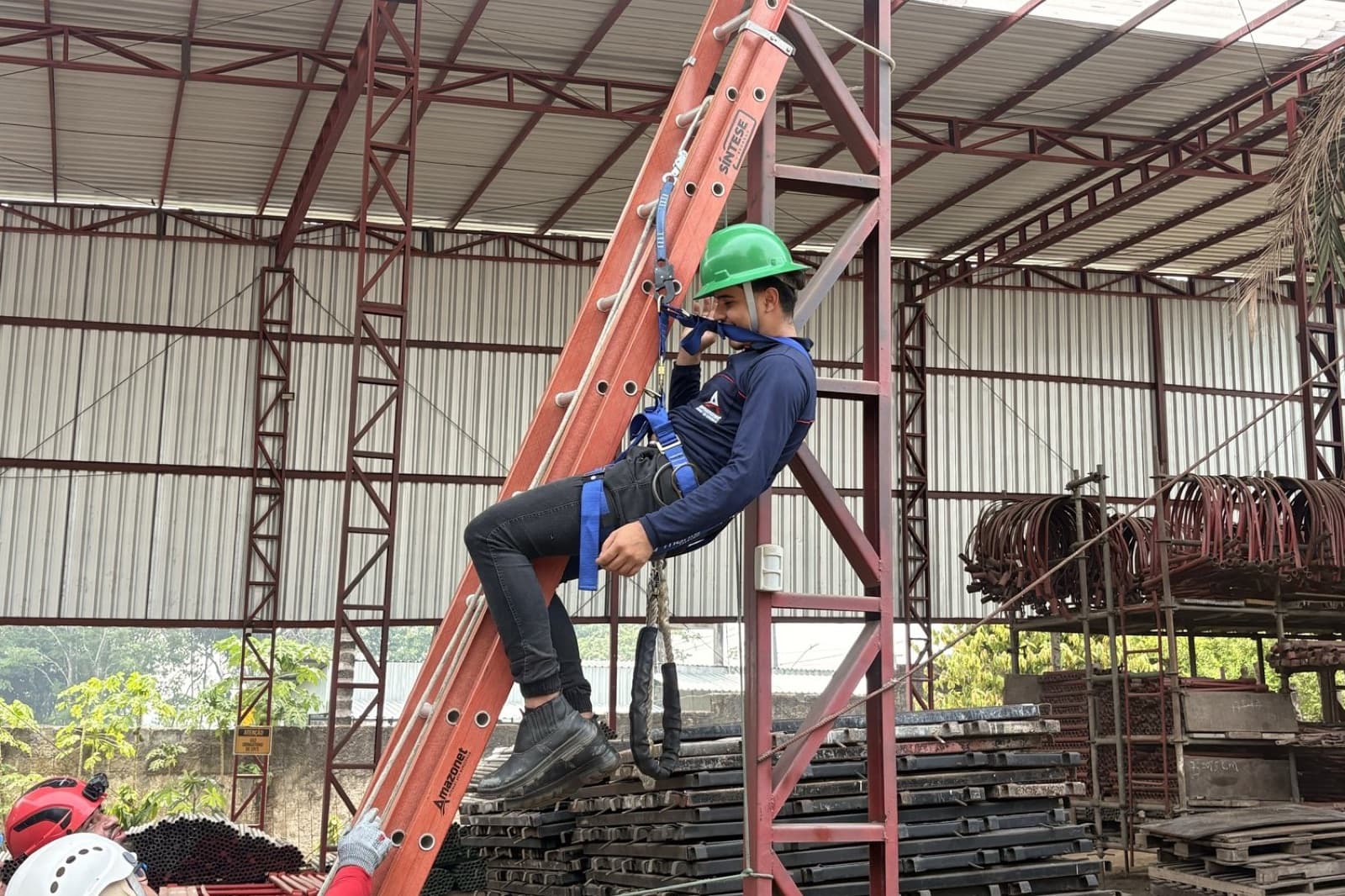 Participante com capacete e talabarte durante a prática em altura