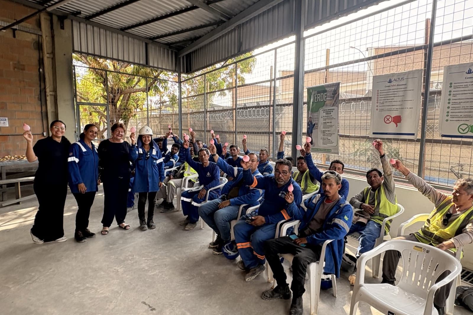 Colaboradores de uniforme azul acompanham a conversa sobre prevenção